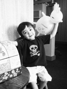 Small boy smiling holding blown up dental gloves